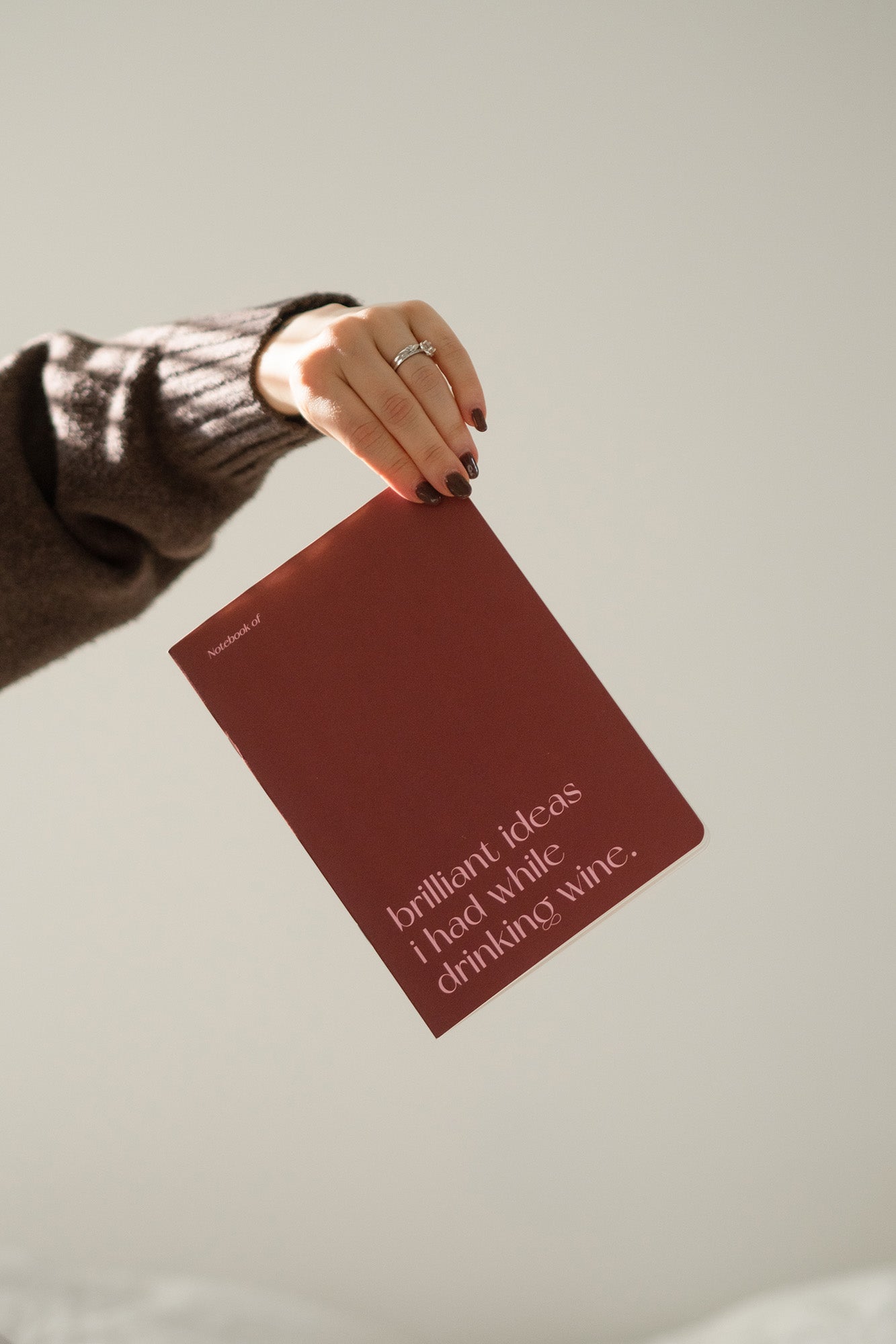 Viininpunainen vihko, jonka kannessa lukee hauska teksti. 